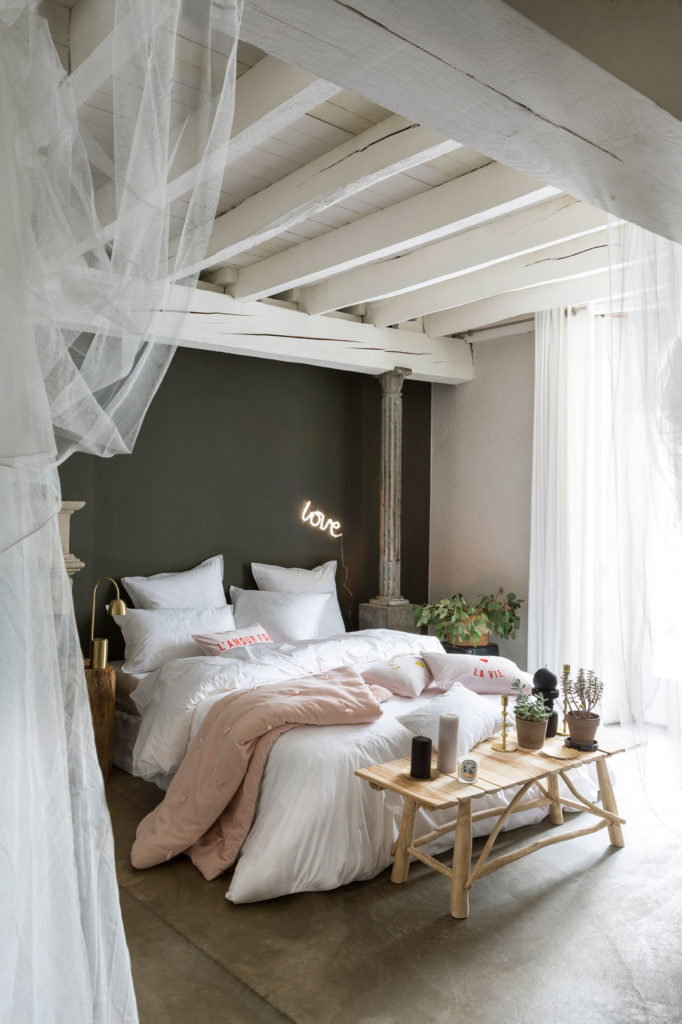 Une chambre avec une parure de lit blanche