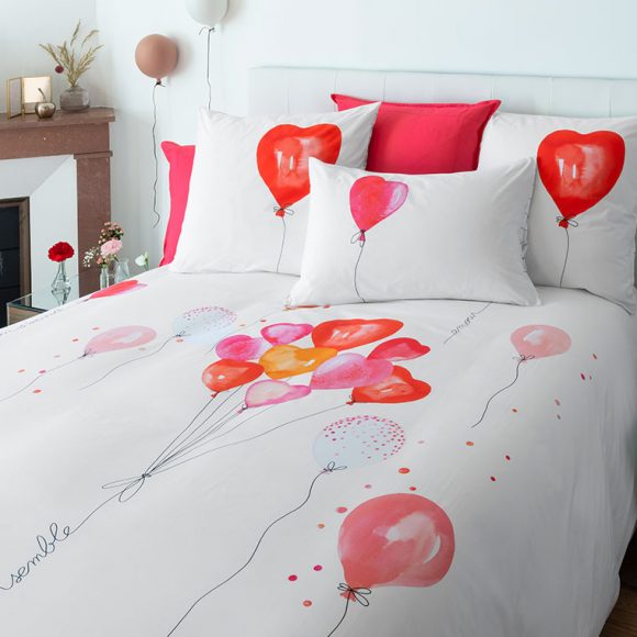Une parure de lit avec des ballons en forme de coeur