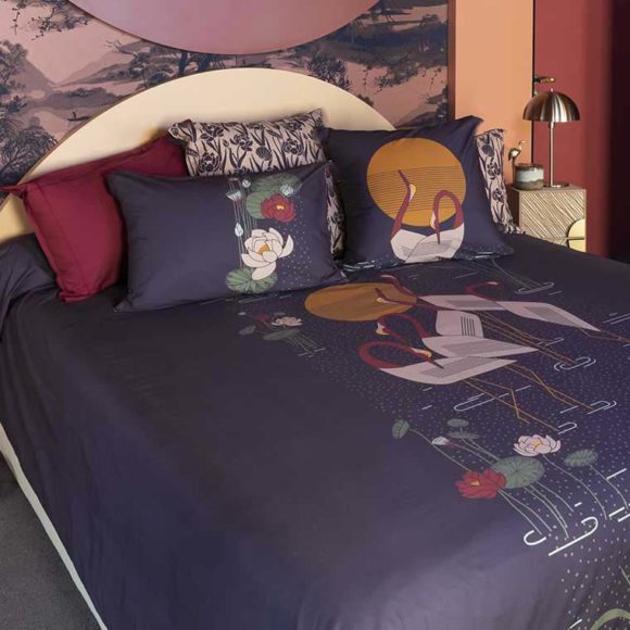 Une chambre avec une parure de lit de couleur violet