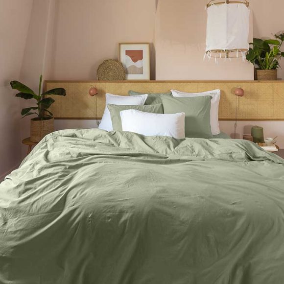 Une chambre avec une parure de lit de couleur vert