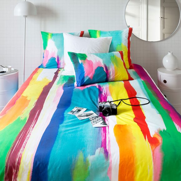 Une chambre avec une parure de lit colorée